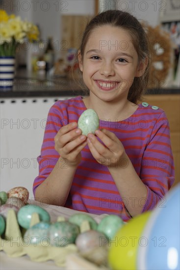 Girl colouring Easter eggs for the Easter basket