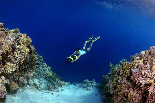 Freediver swimming with underwater scooter