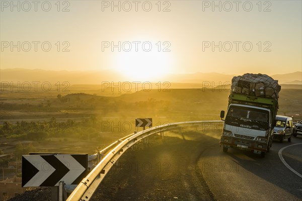 Loaded truck on curvy road in Dades Valley at sunset