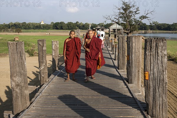 Two Buddhist monks walking on the U Bein Bridge