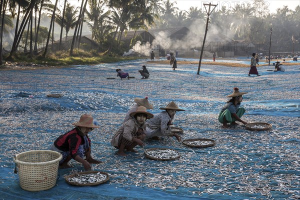 Local women wearing straw hats and Thanaka paste on their faces