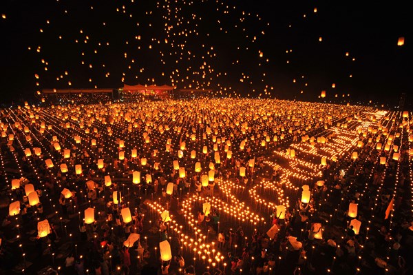 People letting sky lanterns rise