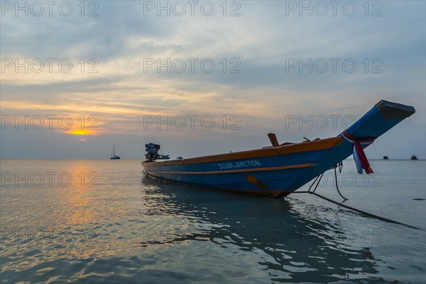 Longtail boat in the sea at sunset