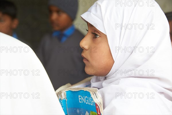 Girl with a book learning english in a primary school