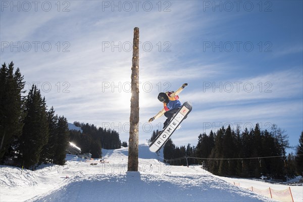 Teenage snowboarder jumping in a funpark