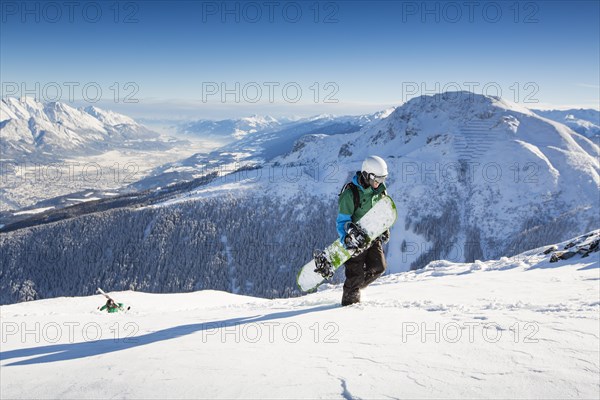 Snowboarders during the ascent overlooking Innsbruck and Inntal valley