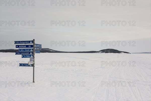 Sign post on frozen over Lake Inari