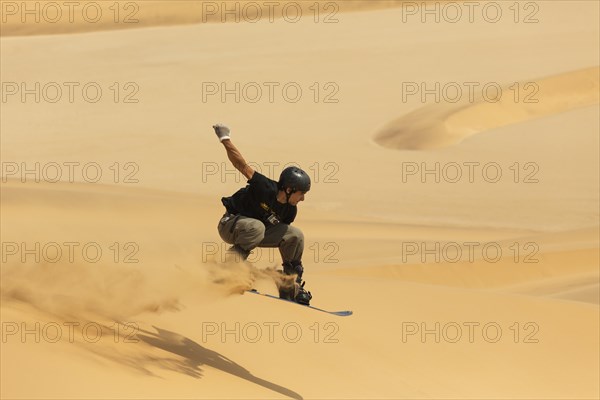 Sand boarding in the dunes of the Namib Desert