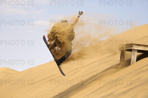 Sand boarding in the dunes of the Namib Desert