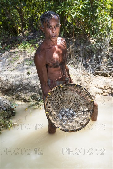 A labourer washing sand to win moonstones