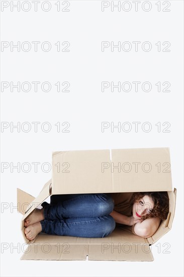 Young woman lying in a removal box