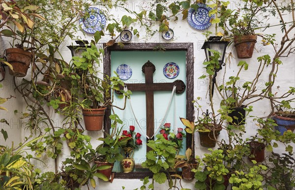 Corner with many potted plants and a cross