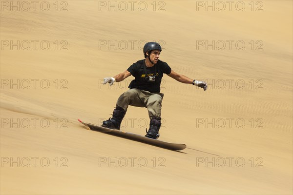 Sand boarding in the dunes of the Namib Desert