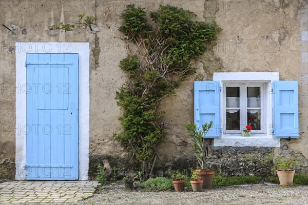 Light blue door and window with light blue shutters