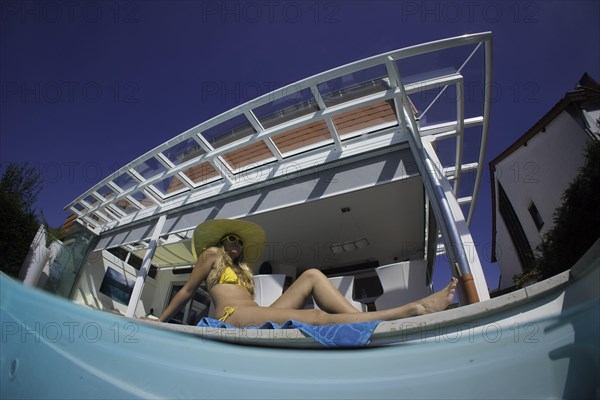 Young woman lying beside a private pool