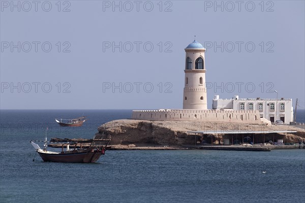 Dhow-ship in front of a lighthouse