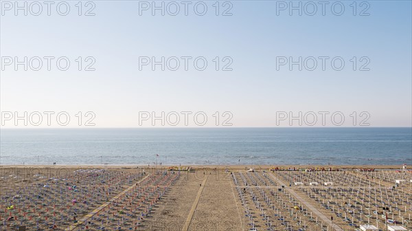 View of a beach with sunshades and sun beds at sunrise
