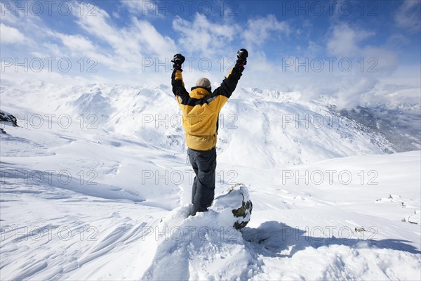 Mountain climber being pleased about reaching the mountain summit