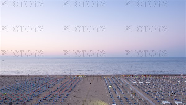 View of a beach with sunshades and sun beds