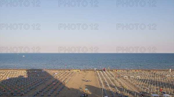 View of a beach with sunshades and sun beds in the late afternoon