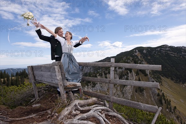 Wedding couple on a mountain throwing the bridal bouquet
