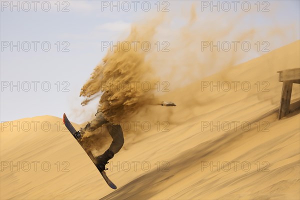 Sand boarding in the dunes of the Namib Desert