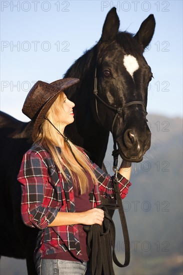 Young woman with a black Hanoverian horse