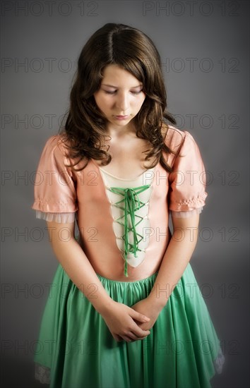 Girl wearing an old-fashioned dress looking sad