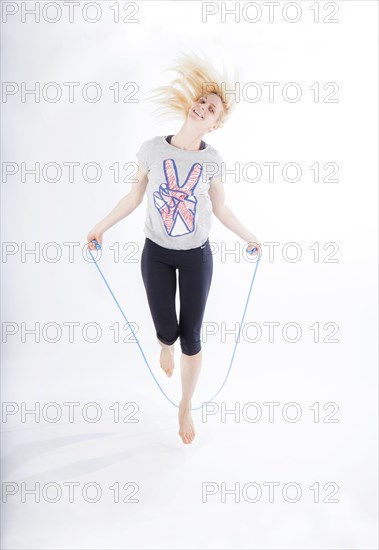 Woman in sportswear jumping rope