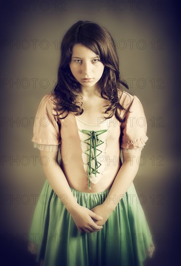 Girl wearing an old-fashioned dress looking sad