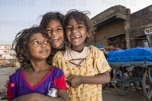 Three smiling street kids