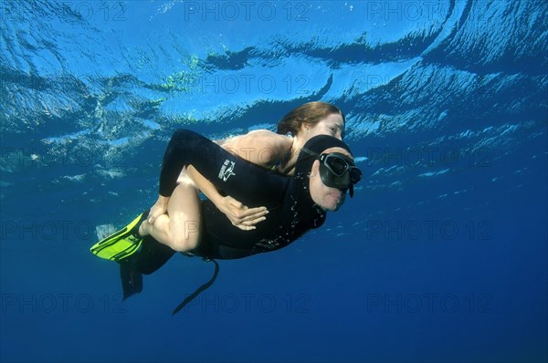 Freediver giving woman a piggyback