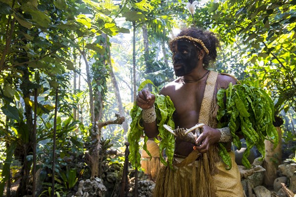 Traditional dressed man with black face in the jungle