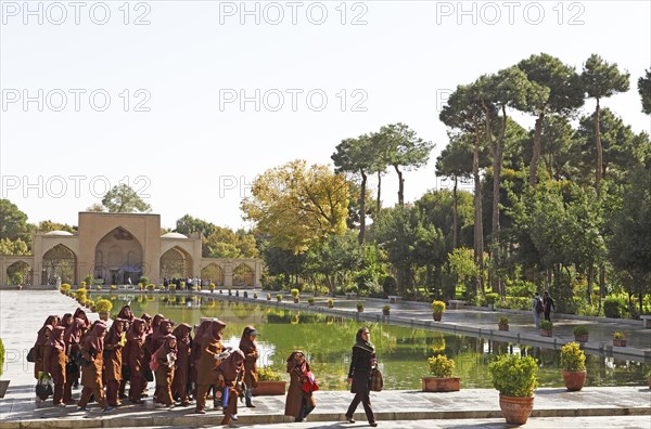 Iranian school class in front of the entrance portal and pool