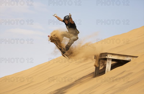 Sand boarding in the dunes of the Namib Desert