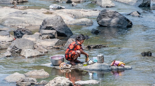 Indian woman washing clothes in a river