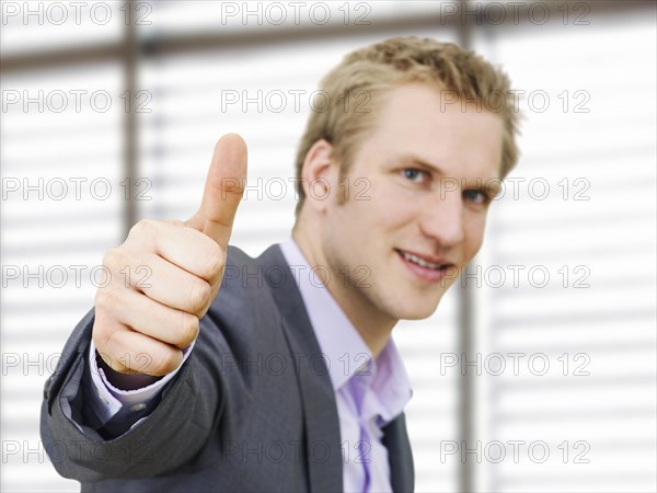 Businessman making a thumbs-up gesture