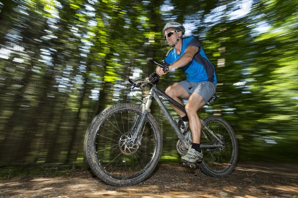 Cyclist on a mountainbike riding through a forest