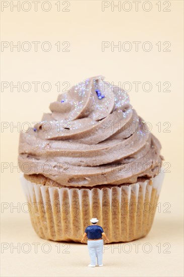 Miniature figurine standing in front of muffin