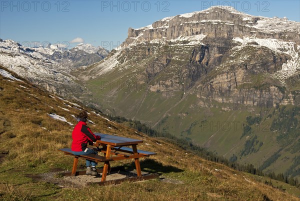 Walker looking from a rest area high above the Urnerboden high valley on the Klausen Pass