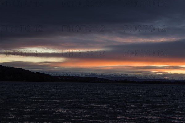 Foehn clouds over Lake Pilsen with snow-covered alpine mountains