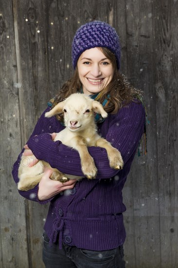 Woman holding a lamb in her arms