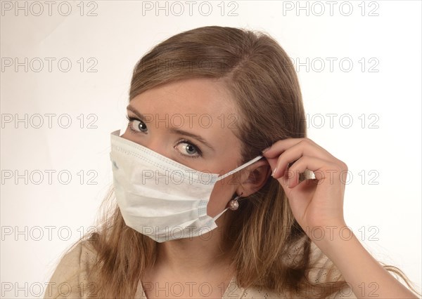 Young woman puts on a face-mask
