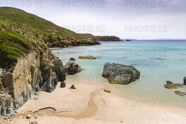 A creek running through the sand of the Spiaggia di Planusartu bay into the sea