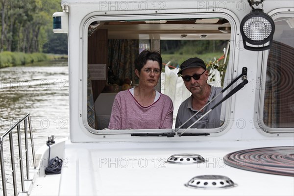 Woman and man at the wheel of a Penichette