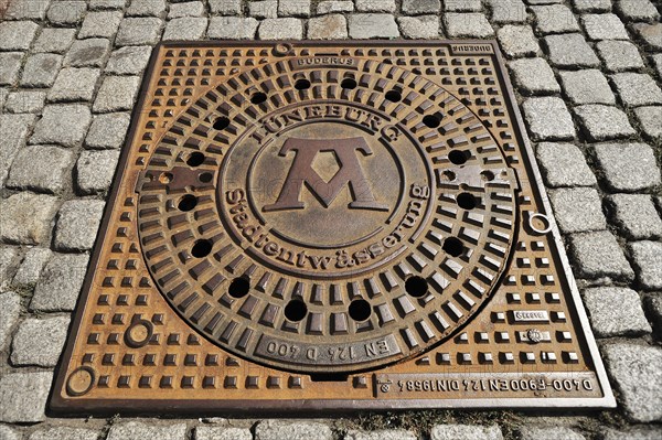Manhole cover with the symbol for the formula 'Mons
