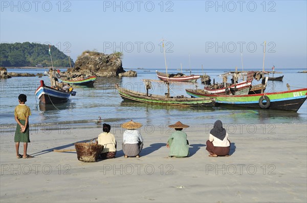 A fisherman's family is waiting on the beach for the return of the boats
