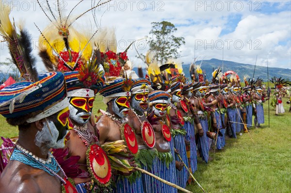 Members of a tribe in colourfully decorated costumes with face paint at the traditional sing-sing gathering