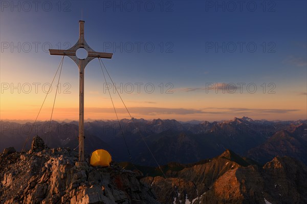 Summit cross with a tent on Grosser Krottenkopf Mountain at sunrise