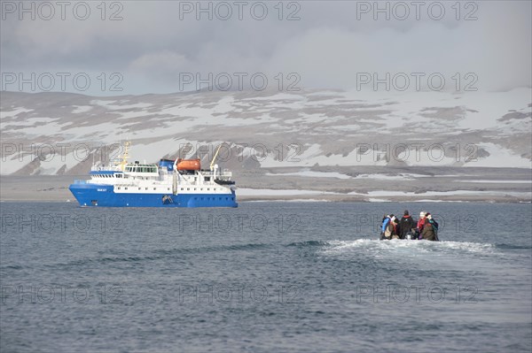 Passengers returning after being ashore in Zodiac inflatable boats to the expedition cruise ship